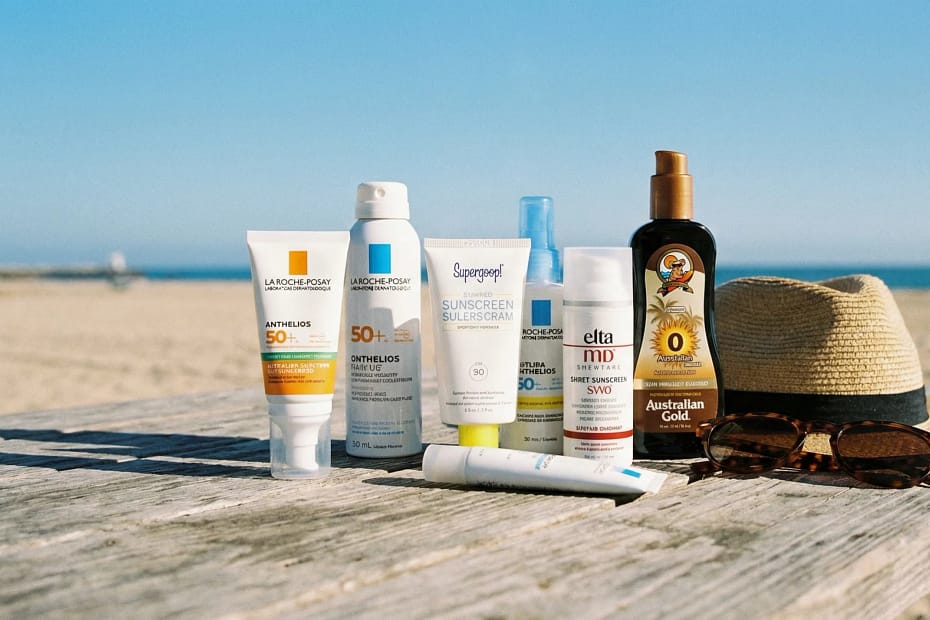 Sunscreen Or How To Protect Your Skin Year-Round Sunscreen products on a beach table
